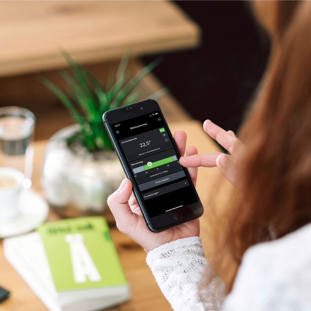 Frau steuert Raumtemperatur via Loxone App auf ihrem Smartphone 